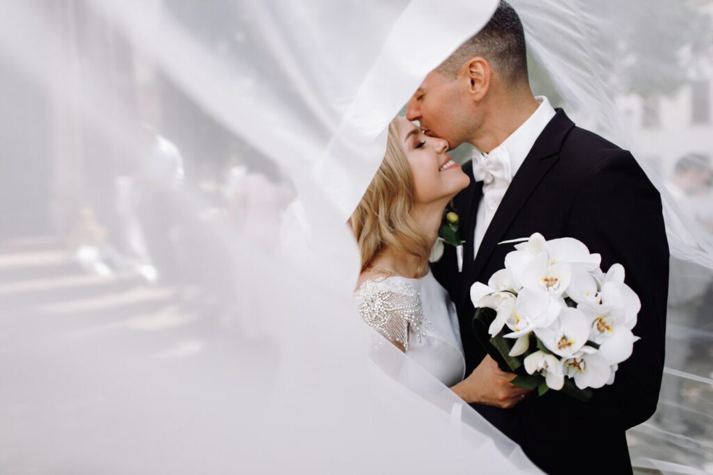 groom-black-tuxedo-hugs-tender-stunning-bride-while-they-stand_8353-8050